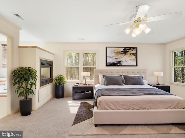  - carpeted bedroom with a ceiling fan, crown molding, and visible vents