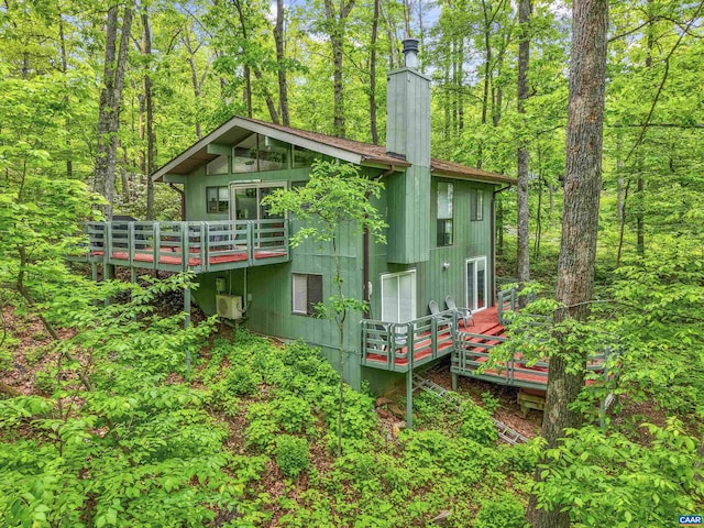 134 Gumtree Dr, Wintergreen Resort, VA 22967 - back of property featuring a wooden deck, ac unit, a chimney, and a forest view