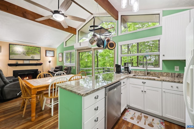 134 Gumtree Dr, Wintergreen Resort, VA 22967 - kitchen with dishwasher, a sink, dark wood-style floors, a warm lit fireplace, and a peninsula