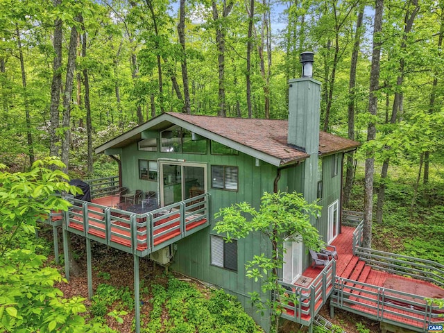 134 Gumtree Dr, Wintergreen Resort, VA 22967 - rear view of house with roof with shingles, a wooden deck, a view of trees, and a chimney