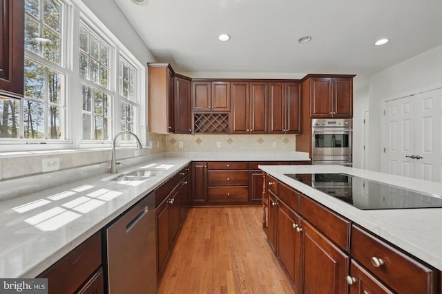 11402 Chivalry Chase Ln, Spotsylvania, VA 22551 - kitchen with stainless steel appliances, a sink, light wood-type flooring, backsplash, and recessed lighting