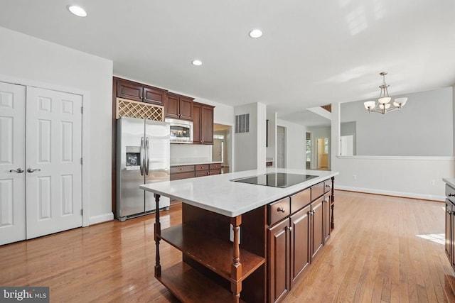 11402 Chivalry Chase Ln, Spotsylvania, VA 22551 - kitchen with appliances with stainless steel finishes, light countertops, a chandelier, light wood-style floors, and open shelves