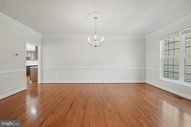 11402 Chivalry Chase Ln, Spotsylvania, VA 22551 - unfurnished dining area with a chandelier, light wood-style flooring, crown molding, and wainscoting