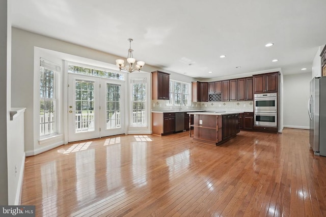 11402 Chivalry Chase Ln, Spotsylvania, VA 22551 - kitchen featuring stainless steel appliances, a chandelier, light countertops, decorative backsplash, and light wood-type flooring
