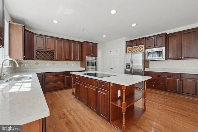 11402 Chivalry Chase Ln, Spotsylvania, VA 22551 - kitchen with stainless steel appliances, a sink, light wood finished floors, light countertops, and decorative backsplash