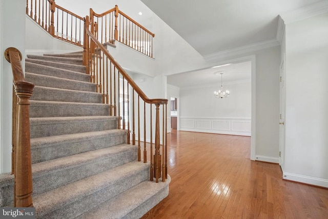 11402 Chivalry Chase Ln, Spotsylvania, VA 22551 - stairway featuring hardwood / wood-style flooring, a chandelier, ornamental molding, a decorative wall, and wainscoting