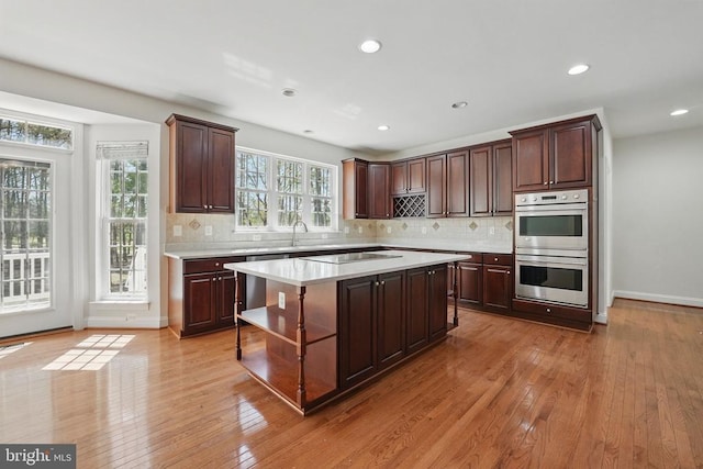 11402 Chivalry Chase Ln, Spotsylvania, VA 22551 - kitchen featuring double oven, light countertops, a center island, light wood-type flooring, and open shelves