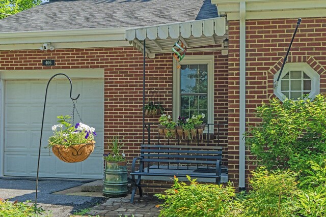406 College Cir, Staunton, VA 24401 - doorway to property with roof with shingles, a garage, brick siding, and a surveillance system