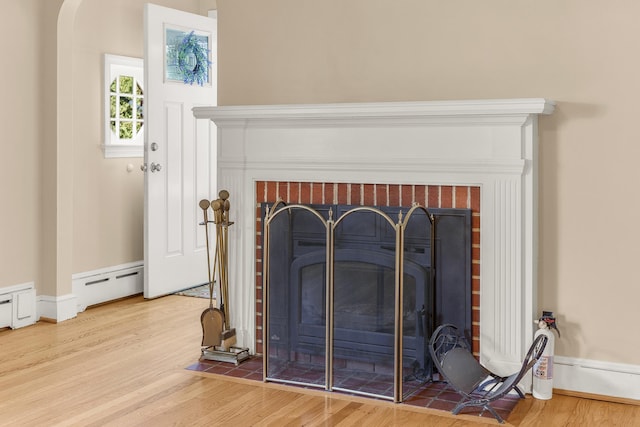 406 College Cir, Staunton, VA 24401 - detailed view of a brick fireplace, a baseboard heating unit, and wood finished floors
