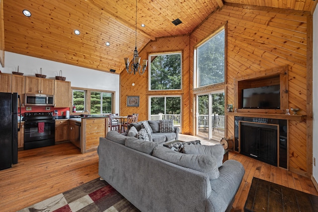 1215 Fort Stover Rd, Luray, VA 22835 - living room with high vaulted ceiling, wood walls, light wood finished floors, a chandelier, and wood ceiling