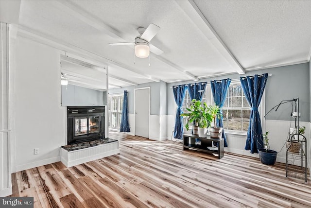 197 Holly Grove Ct, Bumpass, VA 23024 - living area featuring ceiling fan, wood finished floors, a textured ceiling, a multi sided fireplace, and beam ceiling