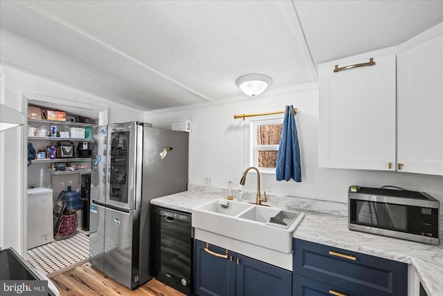 197 Holly Grove Ct, Bumpass, VA 23024 - kitchen featuring stainless steel appliances, a sink, blue cabinetry, light wood finished floors, and crown molding