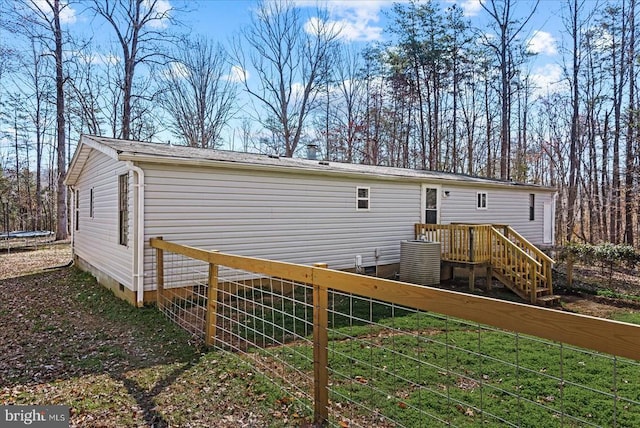 197 Holly Grove Ct, Bumpass, VA 23024 - back of house with crawl space, a trampoline, fence, and central AC unit