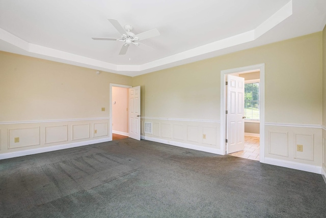 2554 Village Dr, Waynesboro, VA 22980 - unfurnished room with a raised ceiling, carpet flooring, a decorative wall, a ceiling fan, and a wainscoted wall