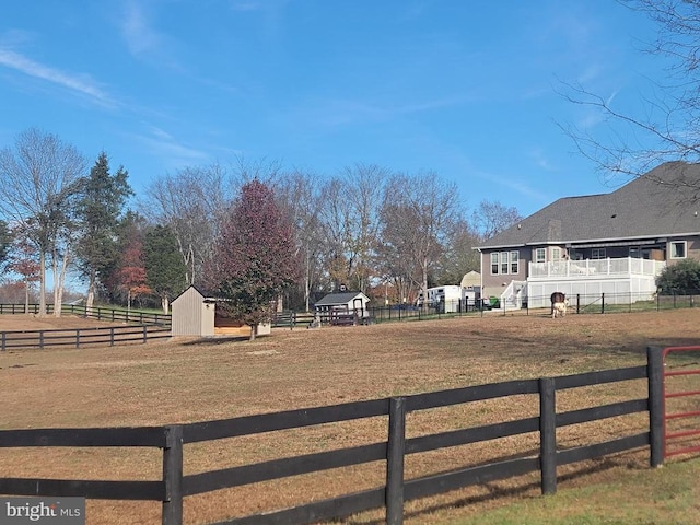 view of yard with an outdoor riding arena, fence, an outdoor structure, and a storage shed