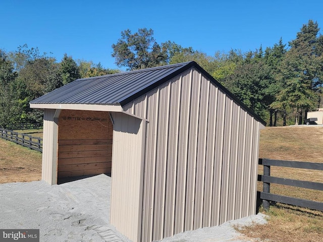 view of outdoor structure featuring fence and an outbuilding
