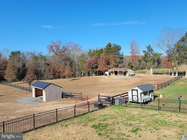 view of community with an outdoor structure, a view of rural / pastoral area, an exterior structure, a storage unit, and fence