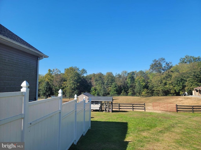view of yard with an outdoor structure and a view of trees