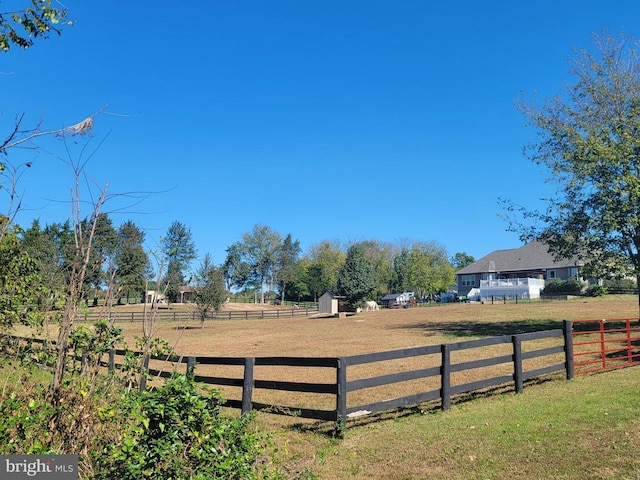 view of yard featuring a storage unit, a rural view, and an outdoor structure