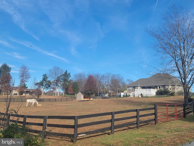 view of yard with fence, an outbuilding, an enclosed horse arena, and a storage shed
