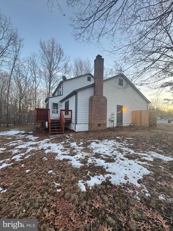 snow covered house with a deck