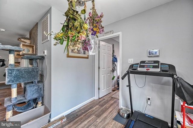 exercise area featuring wood finished floors and baseboards
