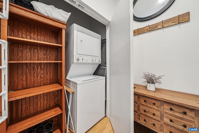 laundry area featuring stacked washer / dryer and wood finished floors