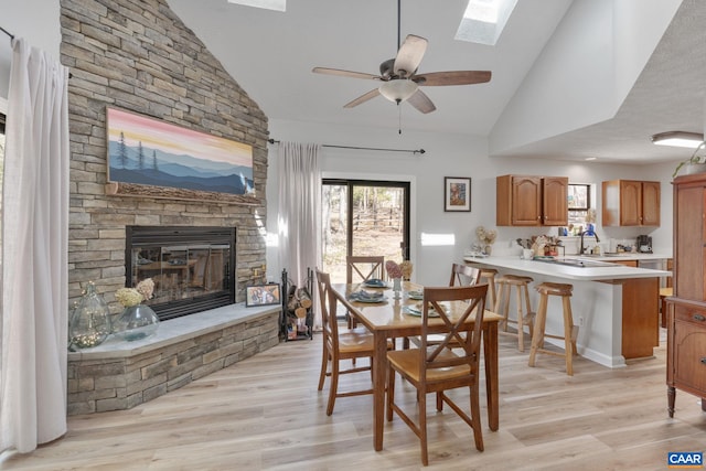 2 Amethyst Rd, Palmyra, VA 22963 - dining space with a stone fireplace, plenty of natural light, light wood-style flooring, and high vaulted ceiling