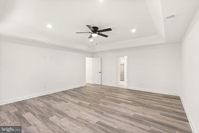  - unfurnished room featuring a ceiling fan, a raised ceiling, wood finished floors, recessed lighting, and baseboards