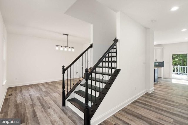  - stairway featuring wood finished floors and recessed lighting