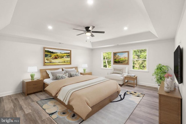  - bedroom featuring a tray ceiling, light wood-style floors, recessed lighting, and ceiling fan