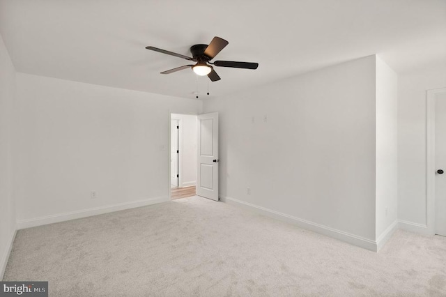  - empty room featuring light colored carpet, a ceiling fan, and baseboards
