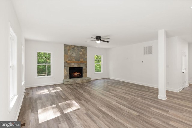  - unfurnished living room featuring a ceiling fan, light wood-style floors, baseboards, and a fireplace