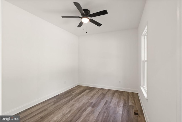  - unfurnished room featuring wood finished floors, a ceiling fan, baseboards, and healthy amount of natural light