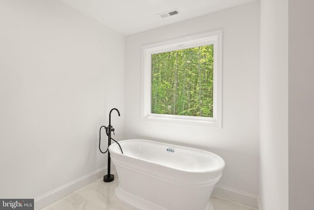  - full bathroom with marble finish flooring, baseboards, and a freestanding bath