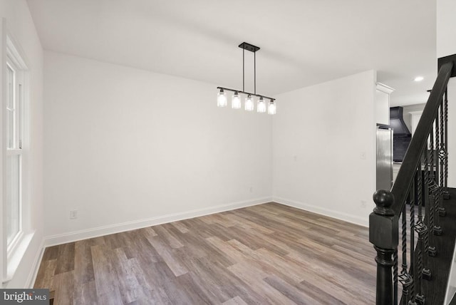  - unfurnished dining area featuring wood finished floors, baseboards, stairs, and recessed lighting