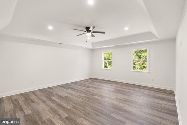  - spare room with a raised ceiling, recessed lighting, ceiling fan, and wood finished floors