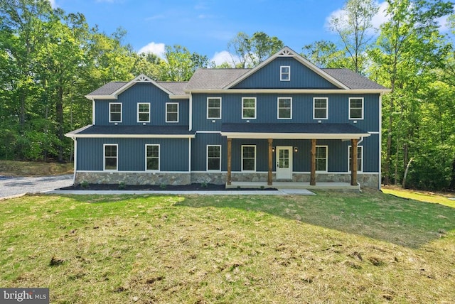  - view of front facade with stone siding, a front yard, and a porch