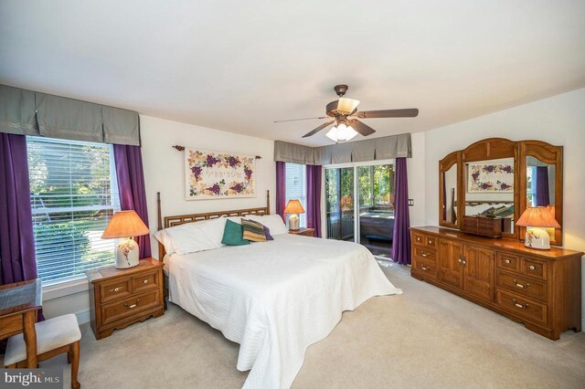bedroom featuring access to exterior, light colored carpet, and ceiling fan