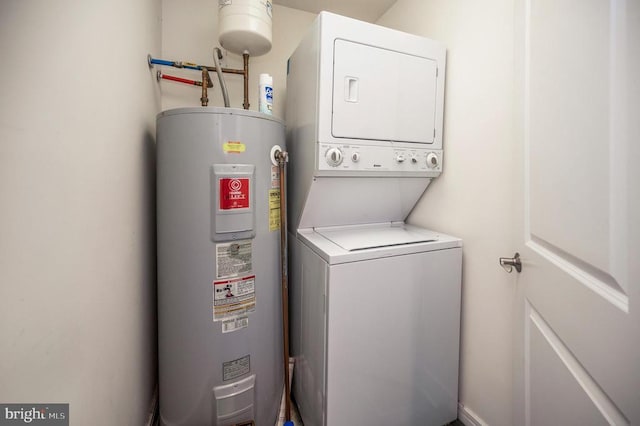 laundry room with electric water heater and estacked washer and dryer