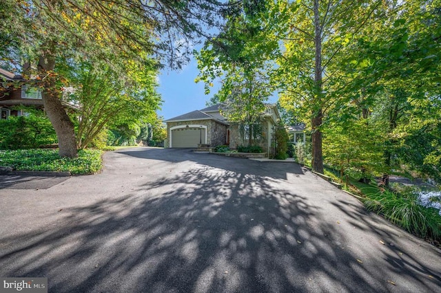 view of front facade featuring asphalt driveway and an attached garage