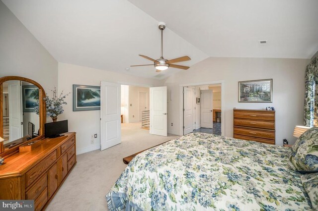 bedroom featuring lofted ceiling, light colored carpet, baseboards, arched walkways, and ceiling fan