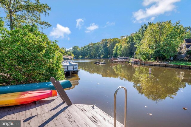 dock area featuring a water view and a wooded view