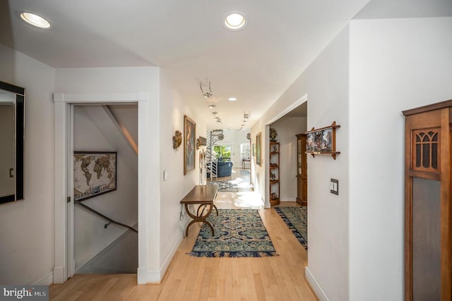 corridor with light wood-type flooring, recessed lighting, and baseboards