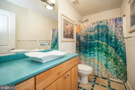 full bathroom with vanity, toilet, curtained shower, and tile patterned floors