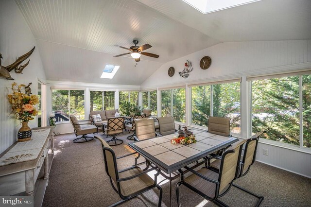 sunroom / solarium with a skylight, vaulted ceiling, and carpet floors