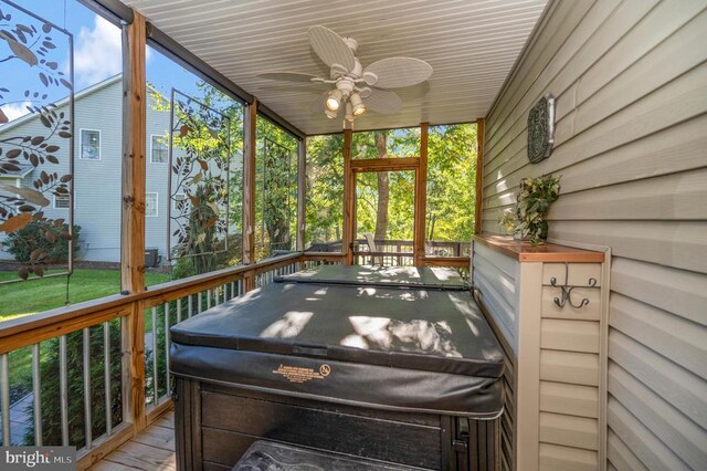 sunroom / solarium with a hot tub and a ceiling fan