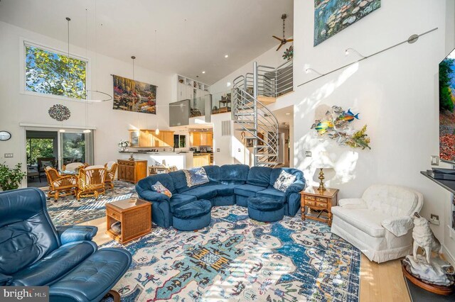 living room featuring a high ceiling, stairway, and wood finished floors
