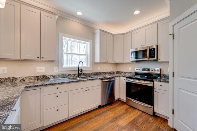 26288 Wisdom Tree Ln, Unionville, VA 22567 - kitchen with appliances with stainless steel finishes, a sink, light wood-style flooring, dark stone countertops, and recessed lighting