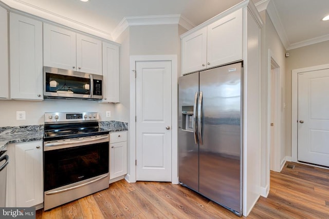 26288 Wisdom Tree Ln, Unionville, VA 22567 - kitchen featuring appliances with stainless steel finishes, crown molding, light wood finished floors, white cabinetry, and dark stone countertops